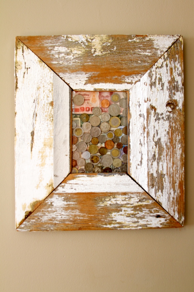foreign coins grace an old wood frame